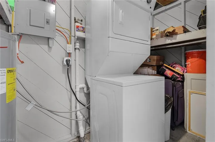 Laundry closet off Storage Room featuring stacked washer and clothes dryer