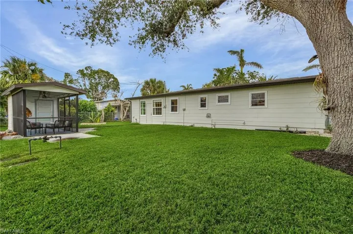 Rear view of property featuring a yard, a patio, and a sunroom