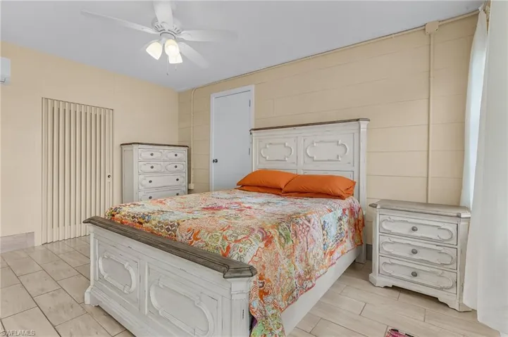 Master Bedroom featuring a booster wall unit AC and ceiling fan