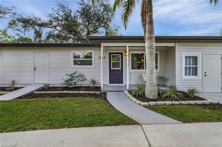View of front of property featuring covered porch and a front lawn
