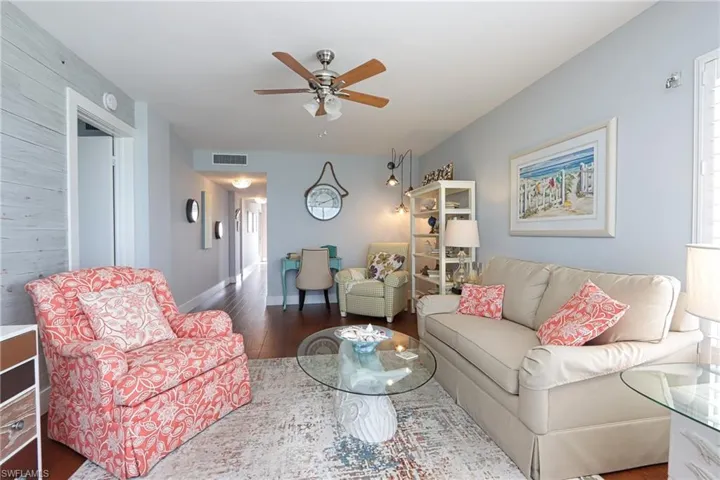 Living room with ceiling fan and dark hardwood / wood-style flooring