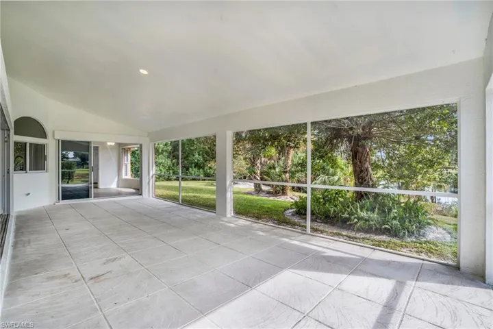 Unfurnished sunroom featuring lofted ceiling