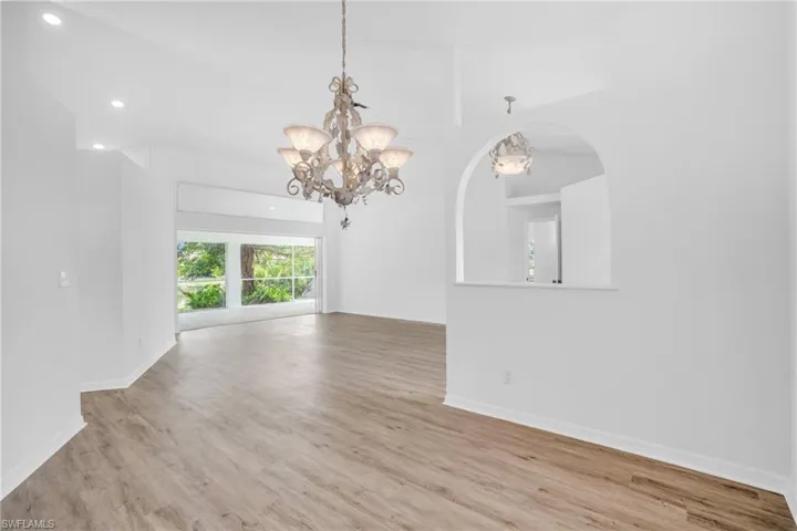 Spare room with a chandelier and light hardwood / wood-style floors