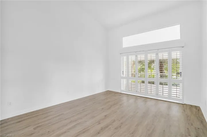 Unfurnished room featuring light hardwood / wood-style floors and high vaulted ceiling