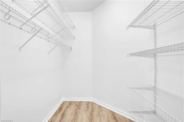 Walk in closet with wood-type flooring