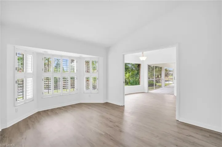 Unfurnished room featuring light hardwood / wood-style flooring and vaulted ceiling