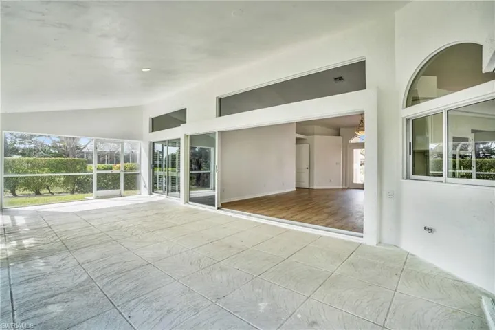 Spare room with high vaulted ceiling and hardwood / wood-style floors