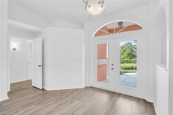 Entrance foyer featuring light hardwood / wood-style flooring and vaulted ceiling