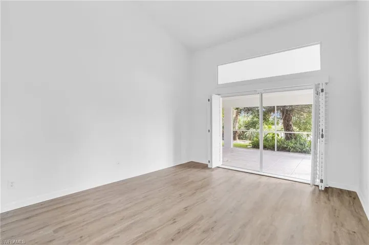 Unfurnished room featuring light hardwood / wood-style floors and high vaulted ceiling