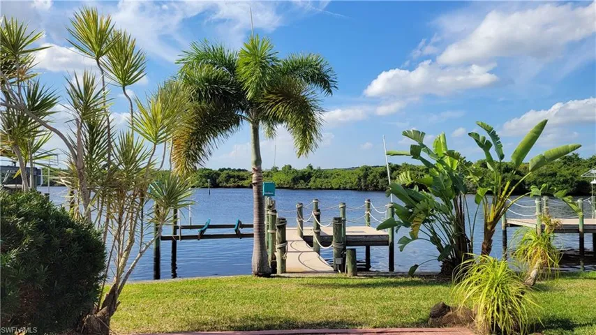 Dock with a water view and a lawn