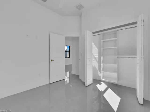 Unfurnished bedroom with visible vents, ceiling fan, and a closet