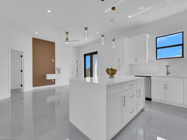 Kitchen featuring a healthy amount of sunlight, stainless steel dishwasher, ceiling fan, and white cabinetry