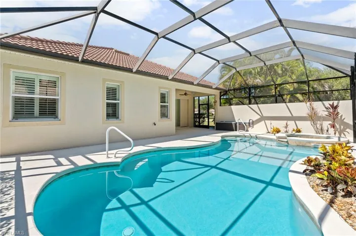 View of swimming pool with a sunroom, a lanai, a patio area, a pool with connected hot tub, and a ceiling fan