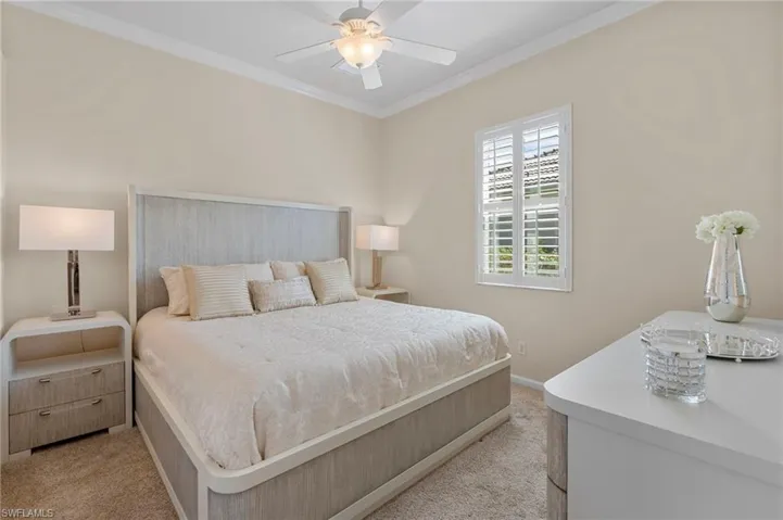 Bedroom featuring ornamental molding, ceiling fan, and light colored carpet