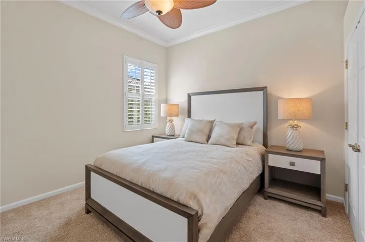 Bedroom featuring crown molding, light colored carpet, and a ceiling fan