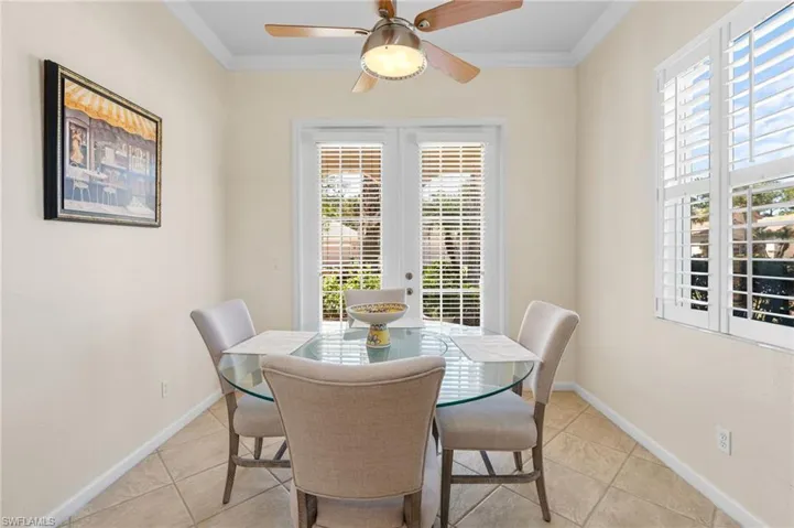 Dining room featuring ornamental molding, light tile patterned flooring, a ceiling fan, and french doors