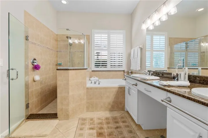 Full bath with a bath, a shower stall, double vanity, light tile patterned floors, and recessed lighting