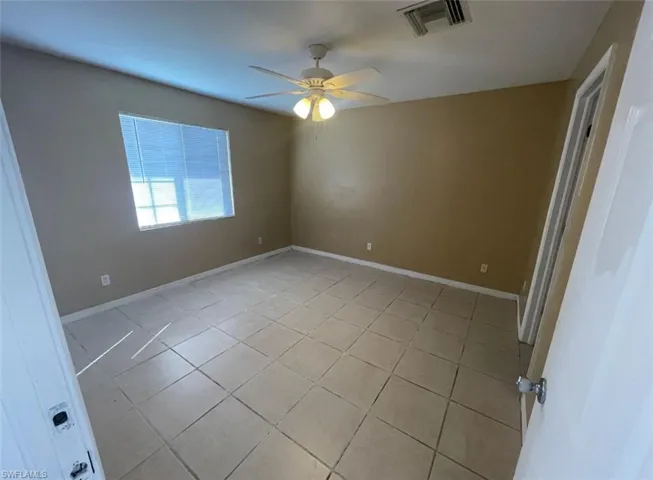 Unfurnished room with visible vents, baseboards, ceiling fan, and light tile patterned floors