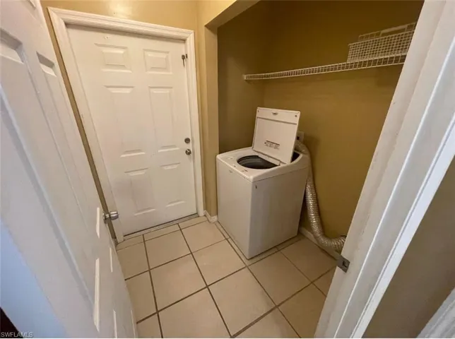 Laundry area featuring light tile patterned floors, laundry area, and washer / clothes dryer