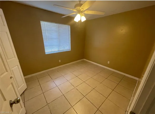Spare room featuring a ceiling fan, baseboards, and light tile patterned floors