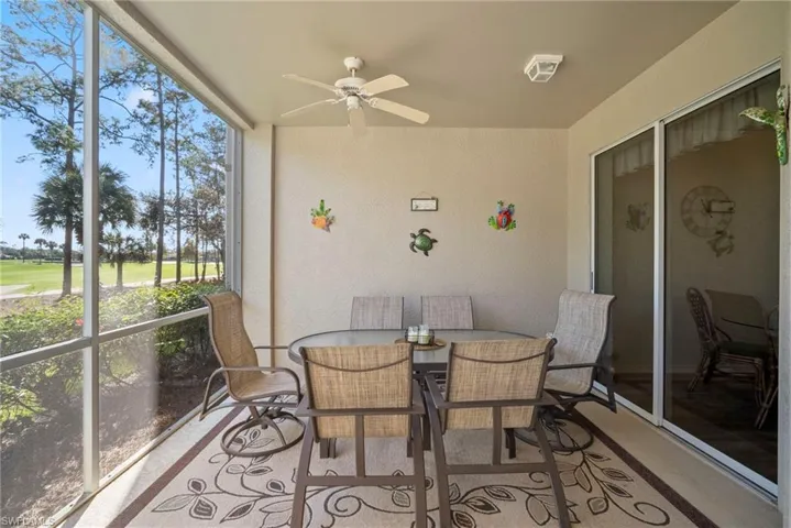 Sunroom with ceiling fan, outdoor dining space, and view of golf course