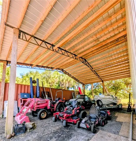 Spacious covered structure featuring a metal roof and exposed wood framing