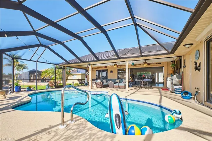Outdoor pool with a ceiling fan, a lanai, an outdoor living space, and a patio