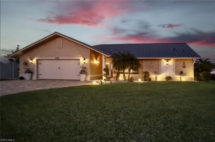 View of front of house with driveway, stucco siding, a garage, and a front yard