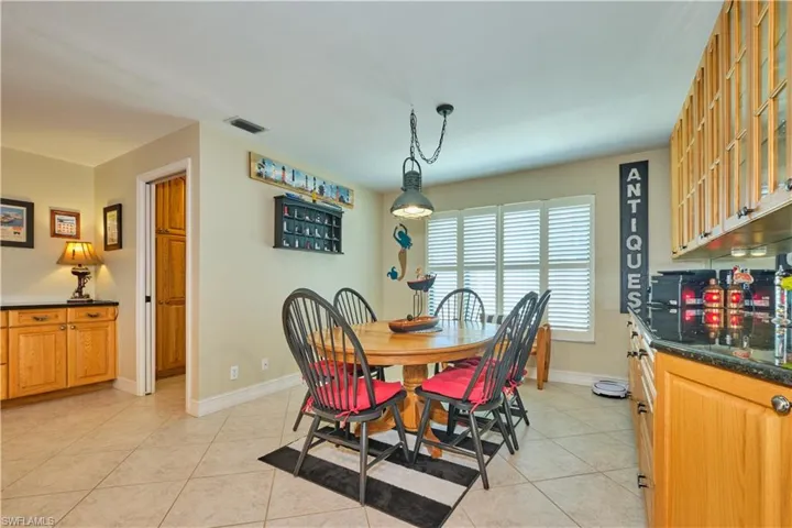 Dining area featuring baseboards, visible vents, indoor bar, and light tile patterned floors