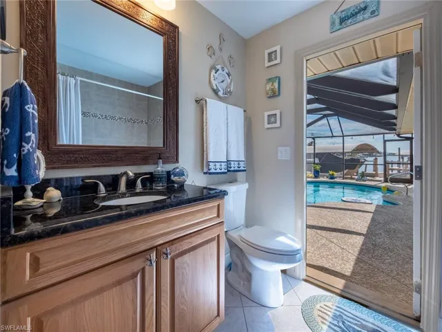 Bathroom featuring tile patterned floors, vanity, toilet, and a shower with shower curtain