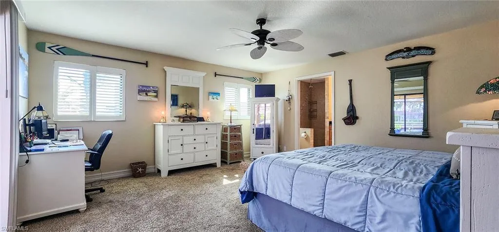 Carpeted bedroom with ceiling fan and a textured ceiling