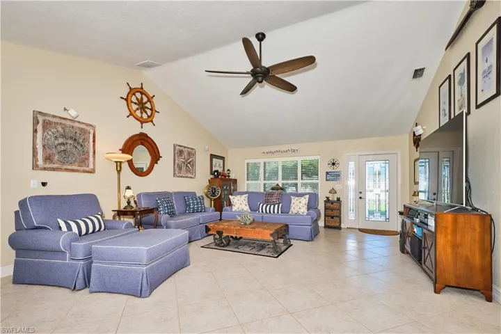 Living room featuring visible vents, high vaulted ceiling, and ceiling fan