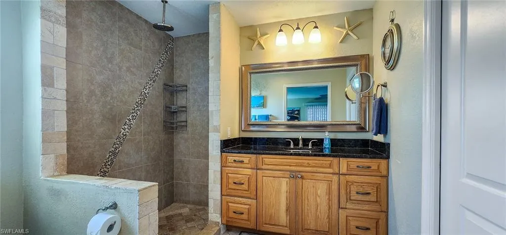 Bathroom with vanity and a tile shower