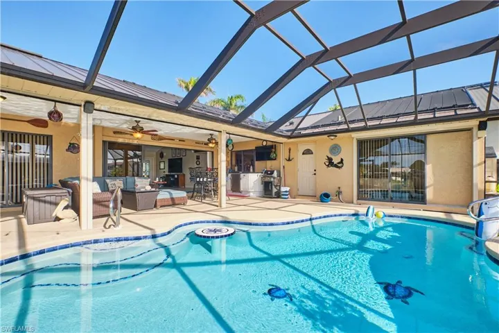 Pool with a patio, glass enclosure, grilling area, a ceiling fan, and outdoor lounge area