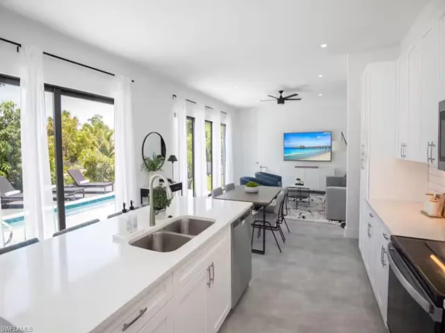 Open-concept kitchen with living space with large format tile flooring and abundant natural light