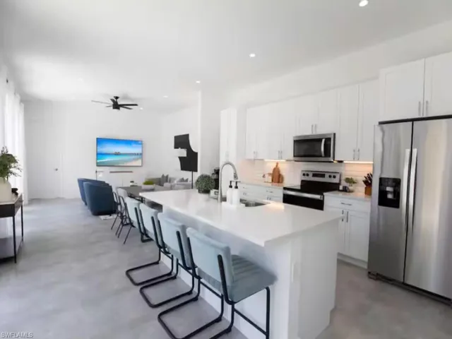 Open-concept living space with a kitchen island featuring a white countertop