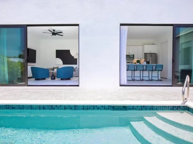 Outdoor swimming pool featuring integrated steps and mosaic tile detailing