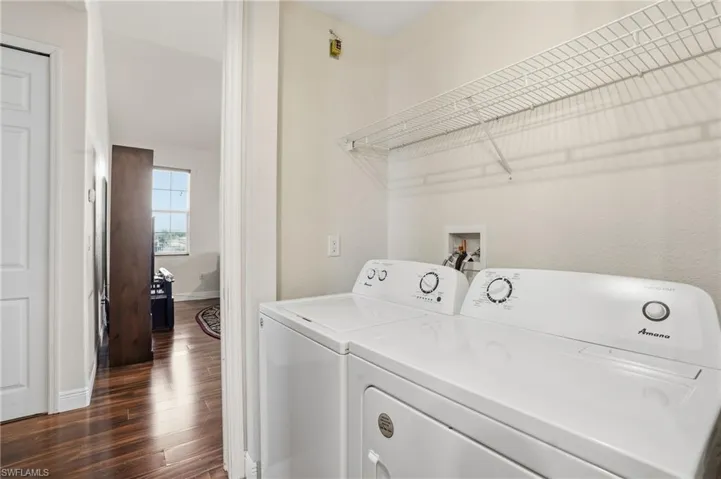 Laundry area with dark wood-type flooring and washer and dryer