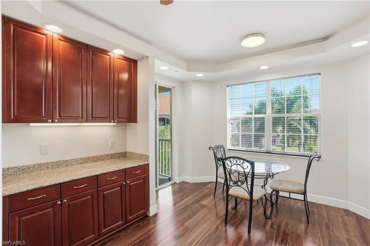 Dining room with dark wood-type flooring, recessed lighting, and a raised ceiling