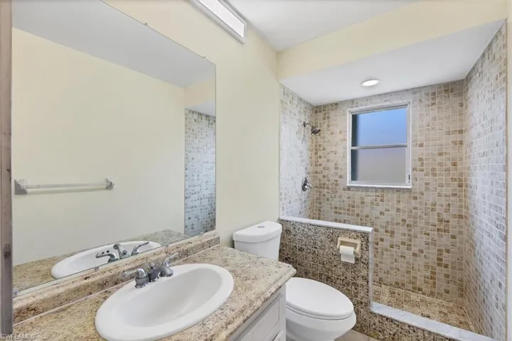Full bathroom with vanity and tiled shower