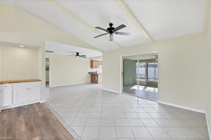 Unfurnished living room with plenty of natural light, light tile patterned flooring, a textured ceiling, and ceiling fan