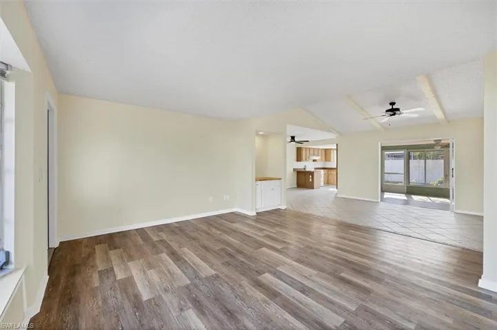 Unfurnished living room featuring light wood finished floors, a ceiling fan, and a textured ceiling