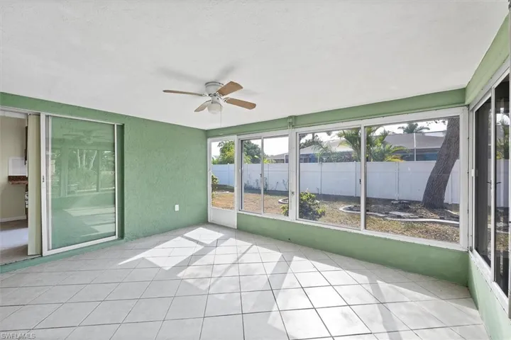 Unfurnished sunroom with ceiling fan