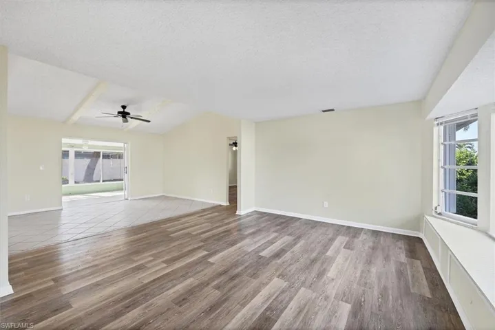 Unfurnished living room with plenty of natural light, a textured ceiling, light wood finished floors, and a ceiling fan