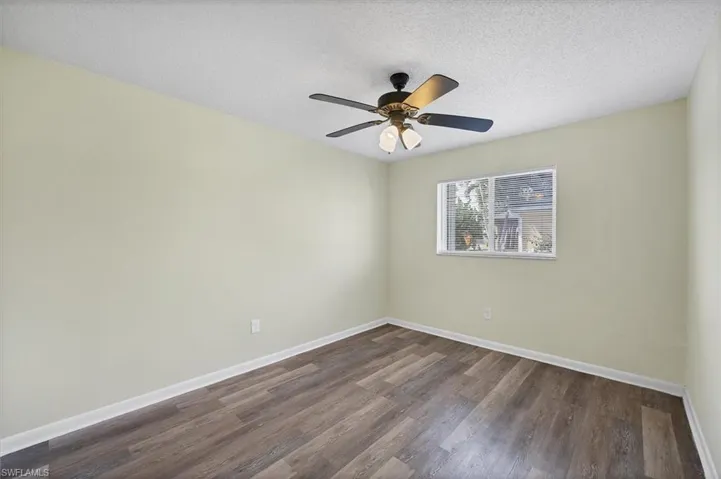Unfurnished room with a textured ceiling, dark wood-type flooring, and a ceiling fan