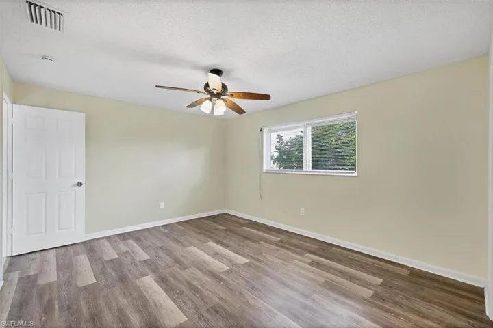 Spare room with a textured ceiling, light wood-type flooring, and ceiling fan