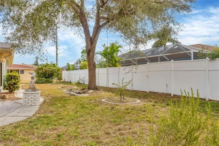 Fenced backyard with glass enclosure and a sunroom