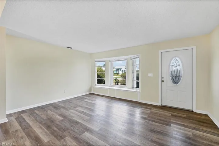 Foyer with a textured ceiling and dark wood-style floors