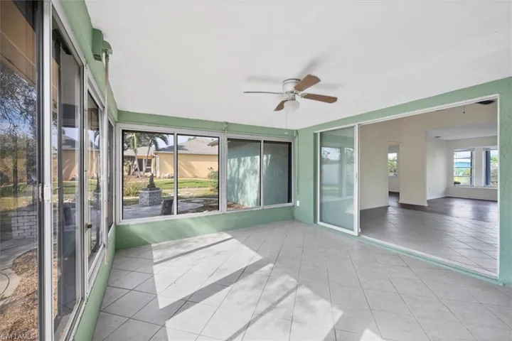 Unfurnished sunroom featuring a ceiling fan