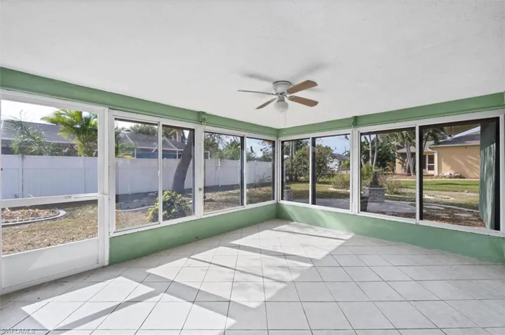 Unfurnished sunroom with a ceiling fan and plenty of natural light